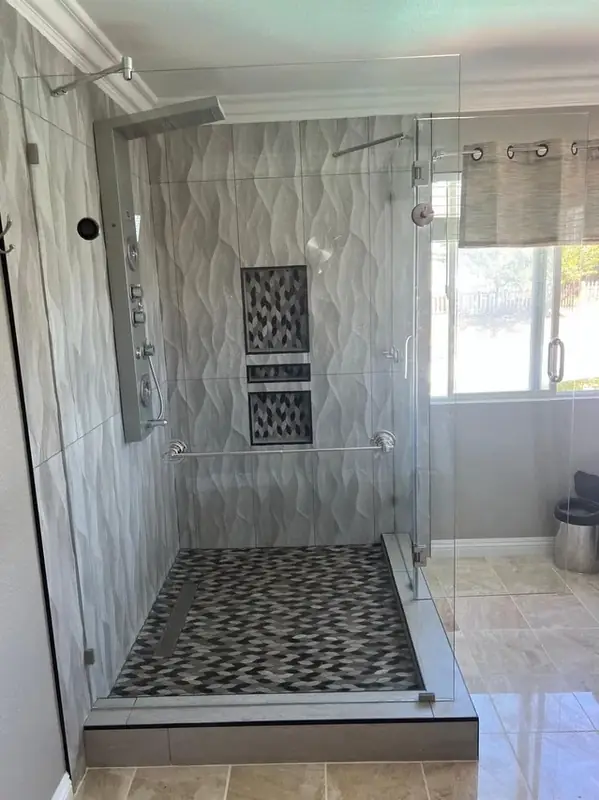 Walk-in marble shower with built-in bench and pebble floor