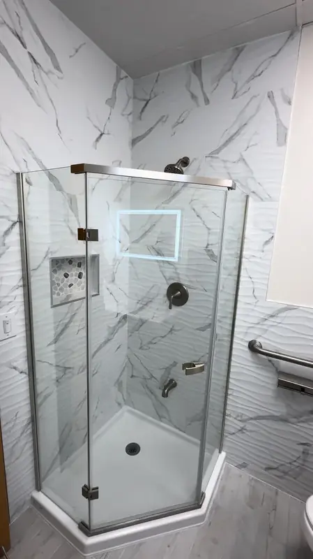 Neo-angle frameless glass shower with white marble tile