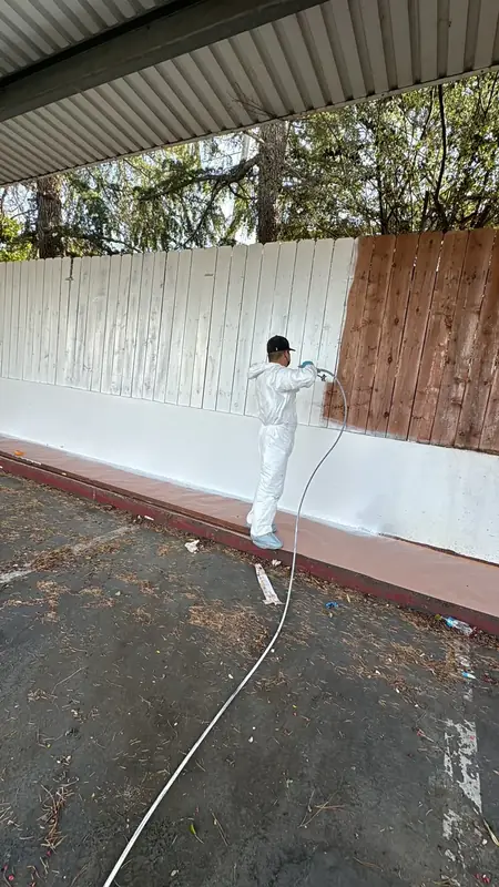 Rock and Iron crew spray-painting an exterior wall