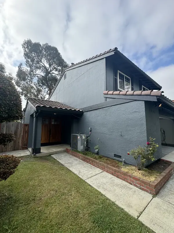 Two-story home repainted in a modern charcoal with crisp trim