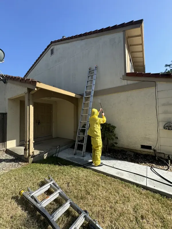 Two-story home before exterior repaint, with faded tan stucco