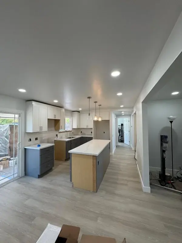 Kitchen with white uppers, blue-gray lowers and a waterfall quartz island