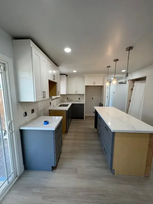 White and blue kitchen with quartz island and pendant lighting