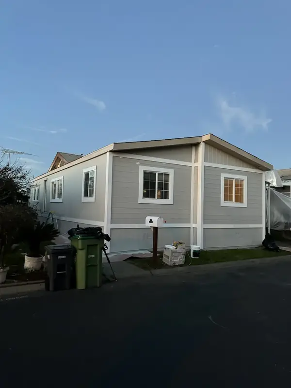 Manufactured home after, with new gray siding and white trim
