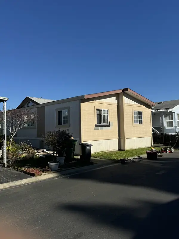 Manufactured home before, with dated tan siding