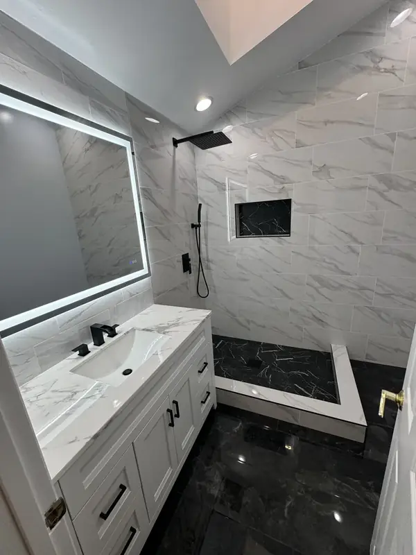 Finished vaulted master bath with white marble walls and black marble floor